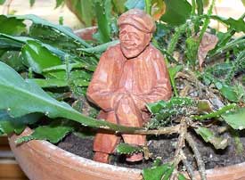 Garden decor - carving of tiny man placed in a potted plant